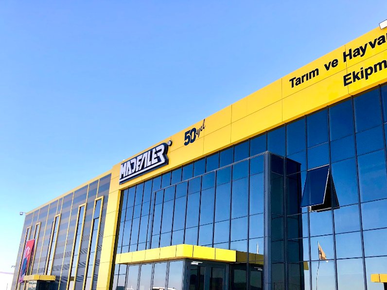 Madenler Makina — Cephe logosu ve ışıklı yazılar · fabrika binası